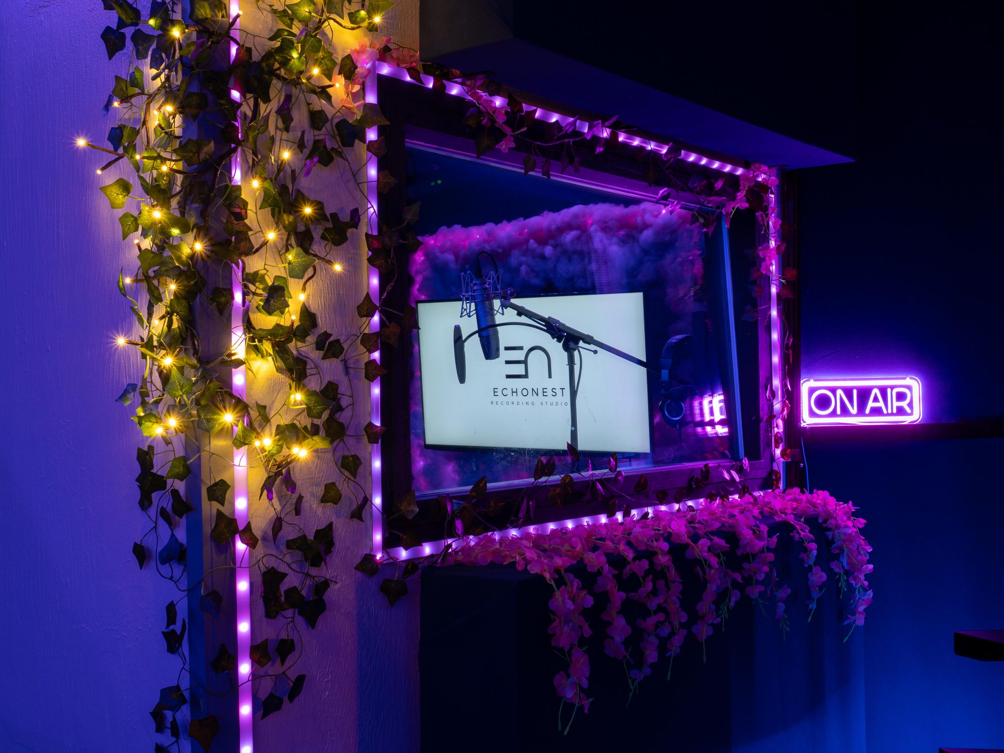 The vocal booth seen from the control room, EchoNest logo lit inside