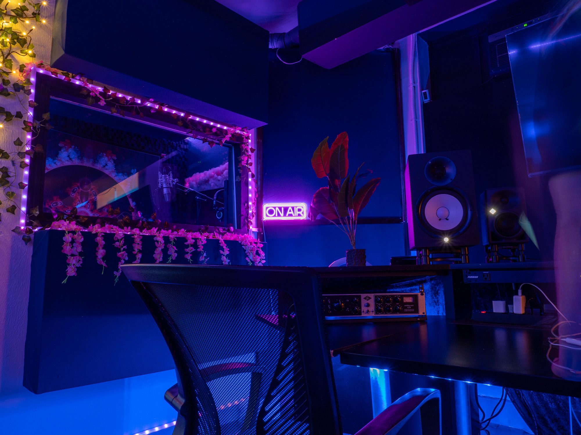 Control room looking through the window into the vocal booth, ON AIR sign lit